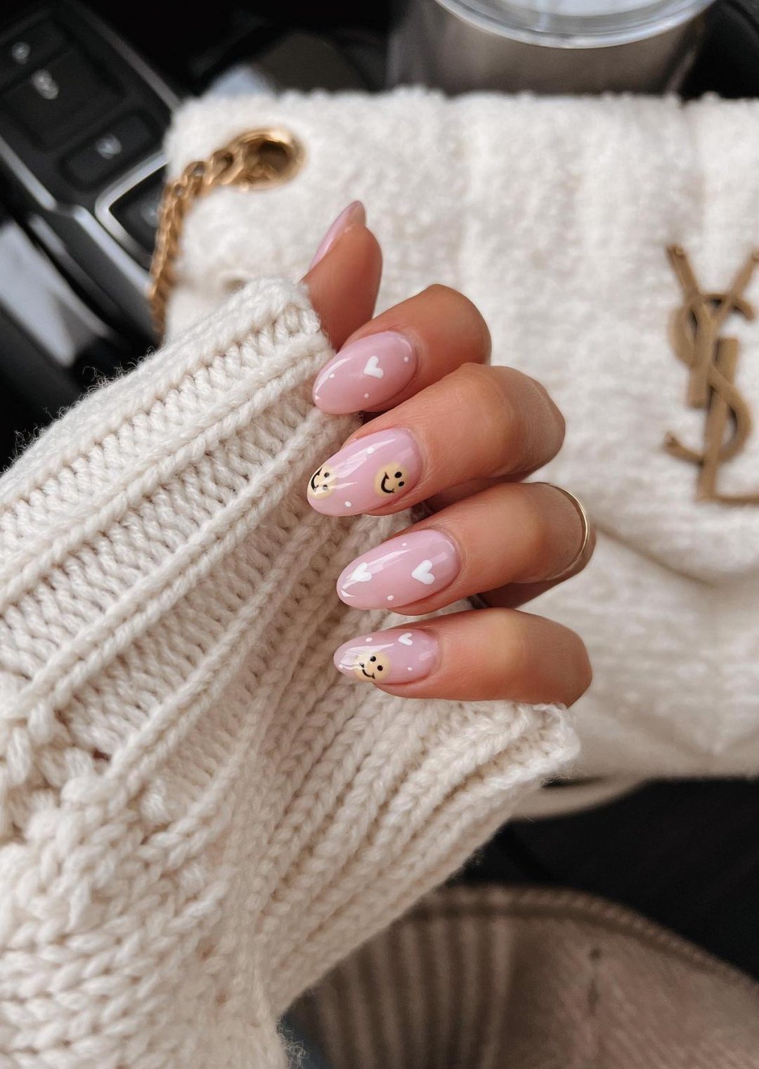 Neutral smiley face nails with hearts.