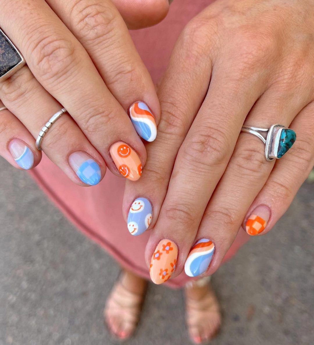 Short blue and orange smiley face nails.