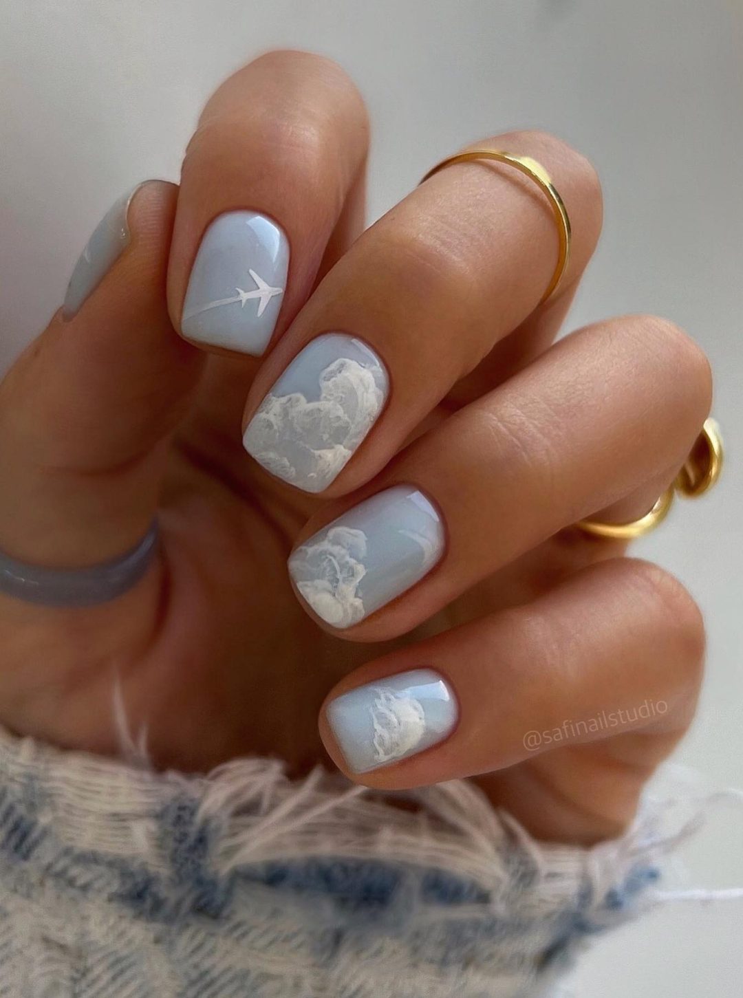 Short light grey nails with clouds.