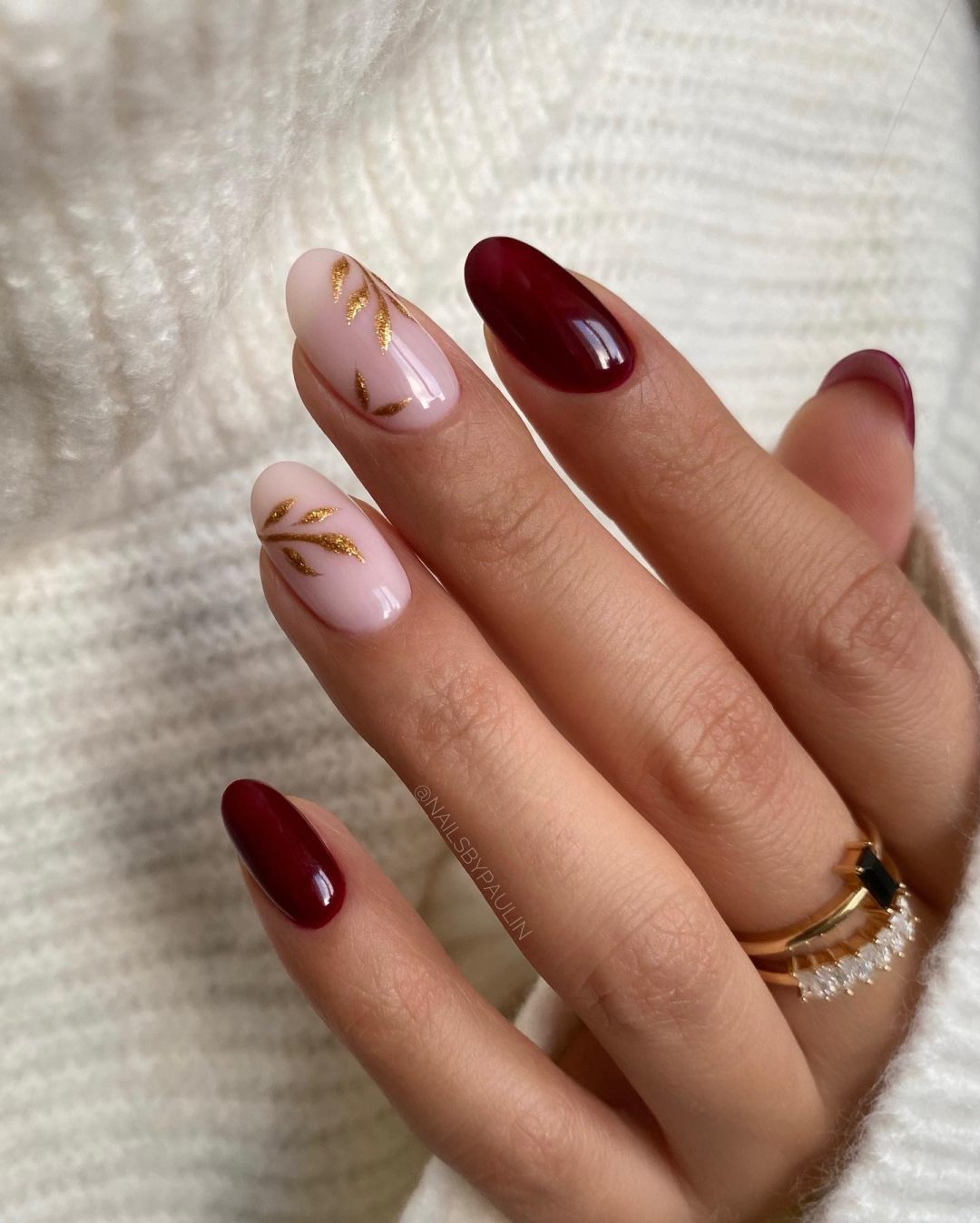 Minimalist burgundy nails with gold flower art.