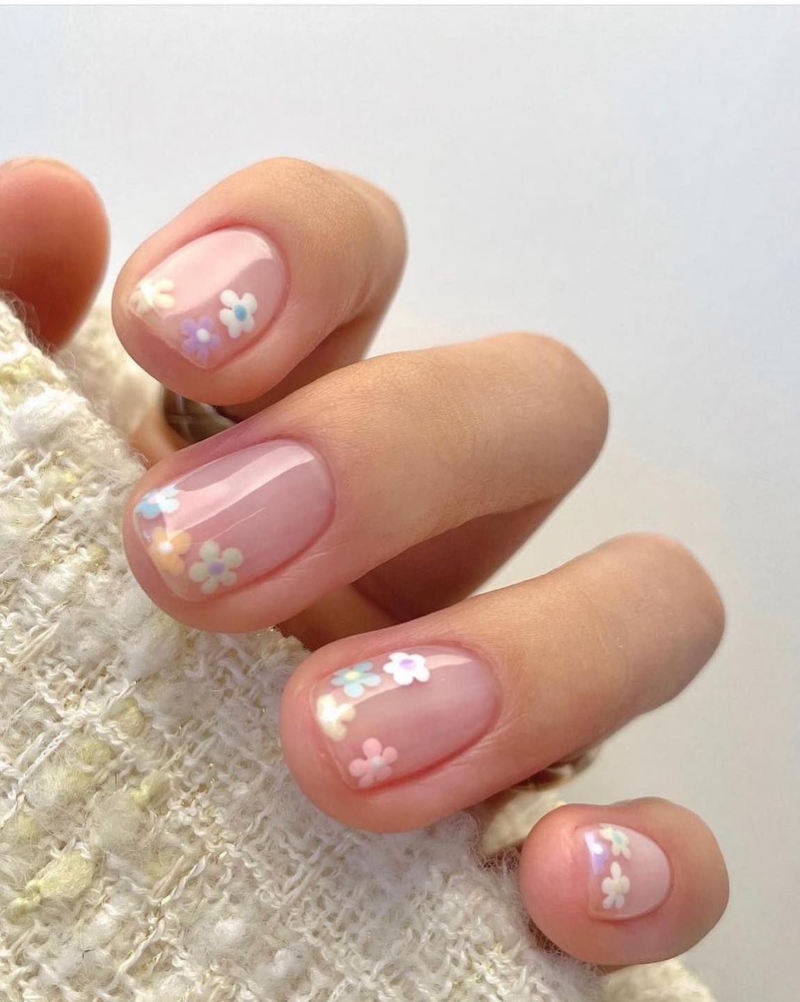 Short natural nails with pastel flower nail art.