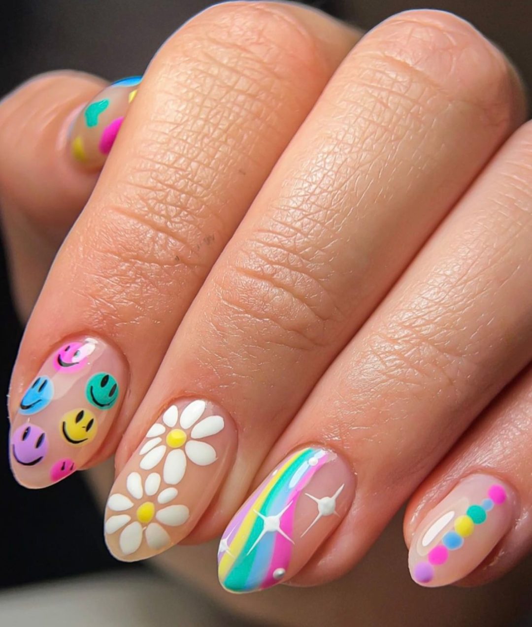 Colorful and short rainbow nails with smiley face art.