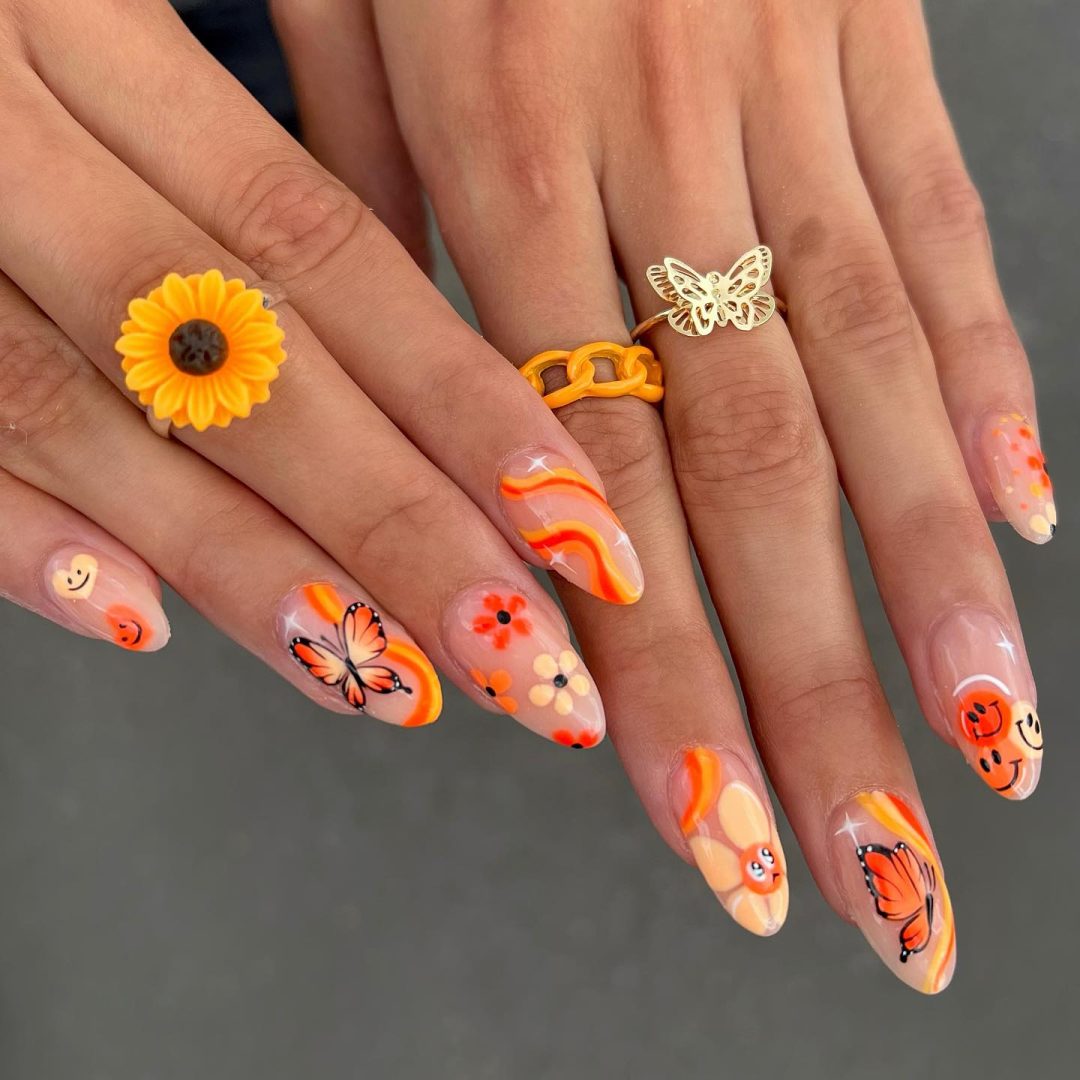 Orange retro nails with smiley faces and butterflies.