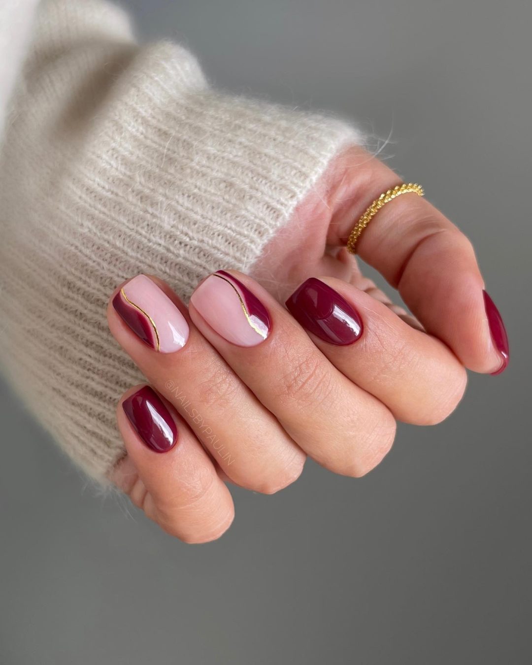 Short burgundy swirl nails.