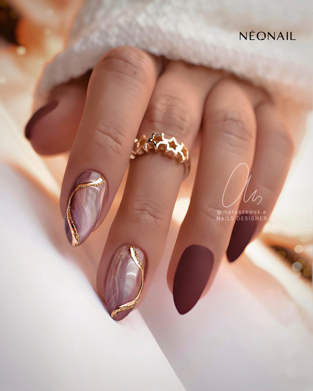 Matte burgundy and gold nails.