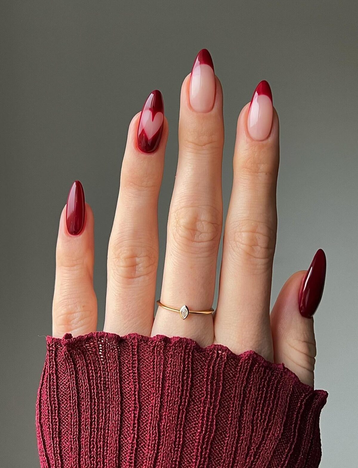 Burgundy nails with a heart and French tips.