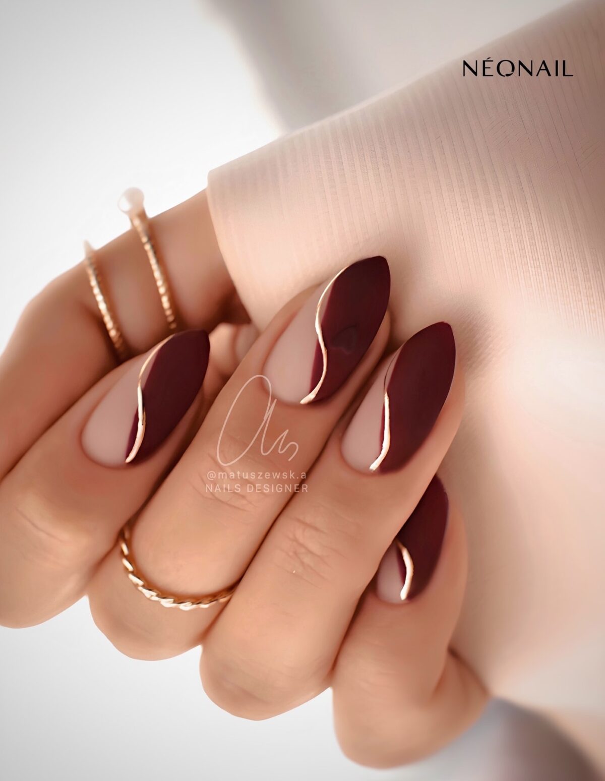 Matte burgundy nails with gold swirls