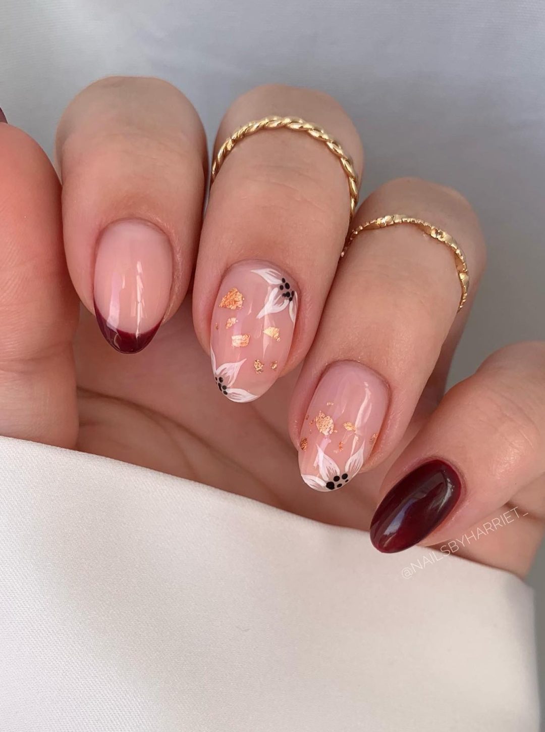 Neutral and burgundy flower nails.