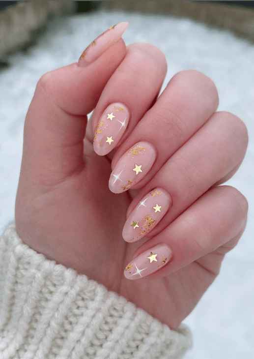 gold star new years eve nail art. winter nail ideas. january nails. nude pink nails with gold stars.