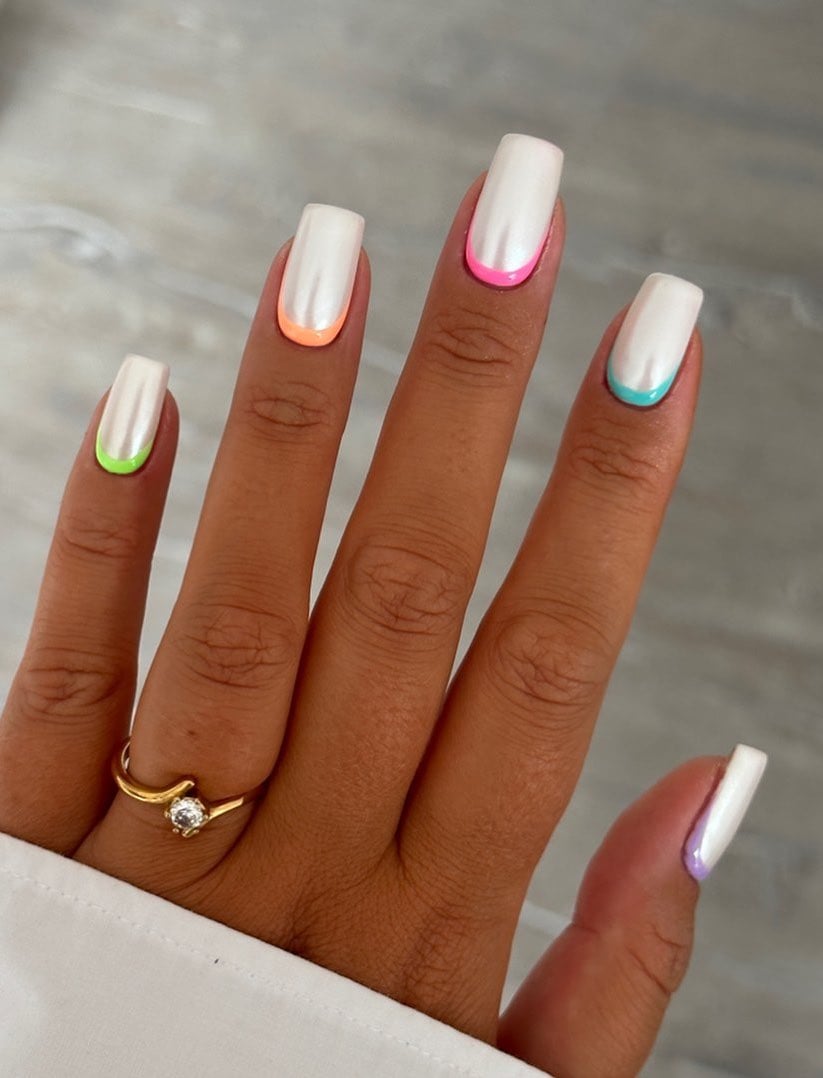 White chrome nails with neon reverse French manicure.