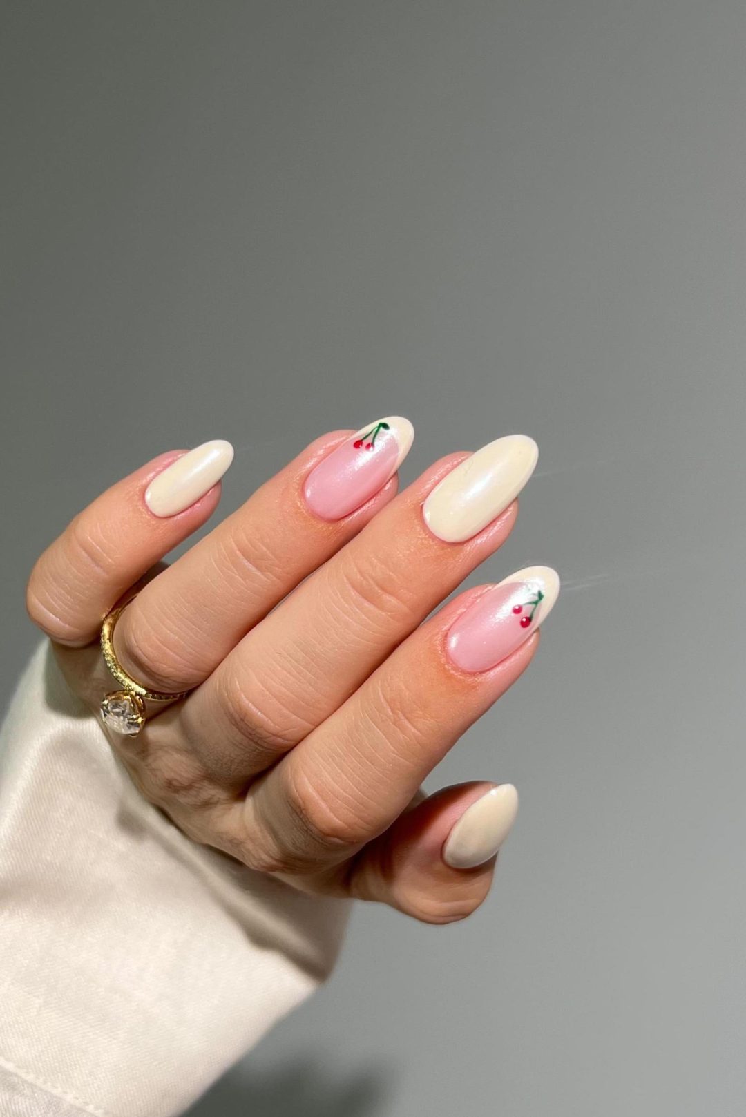 Milky white French tip nails with cherry nail art.