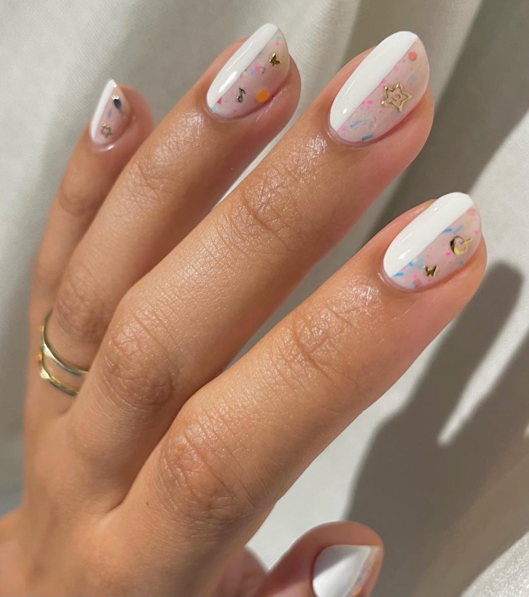 Short white nails with confetti effect.