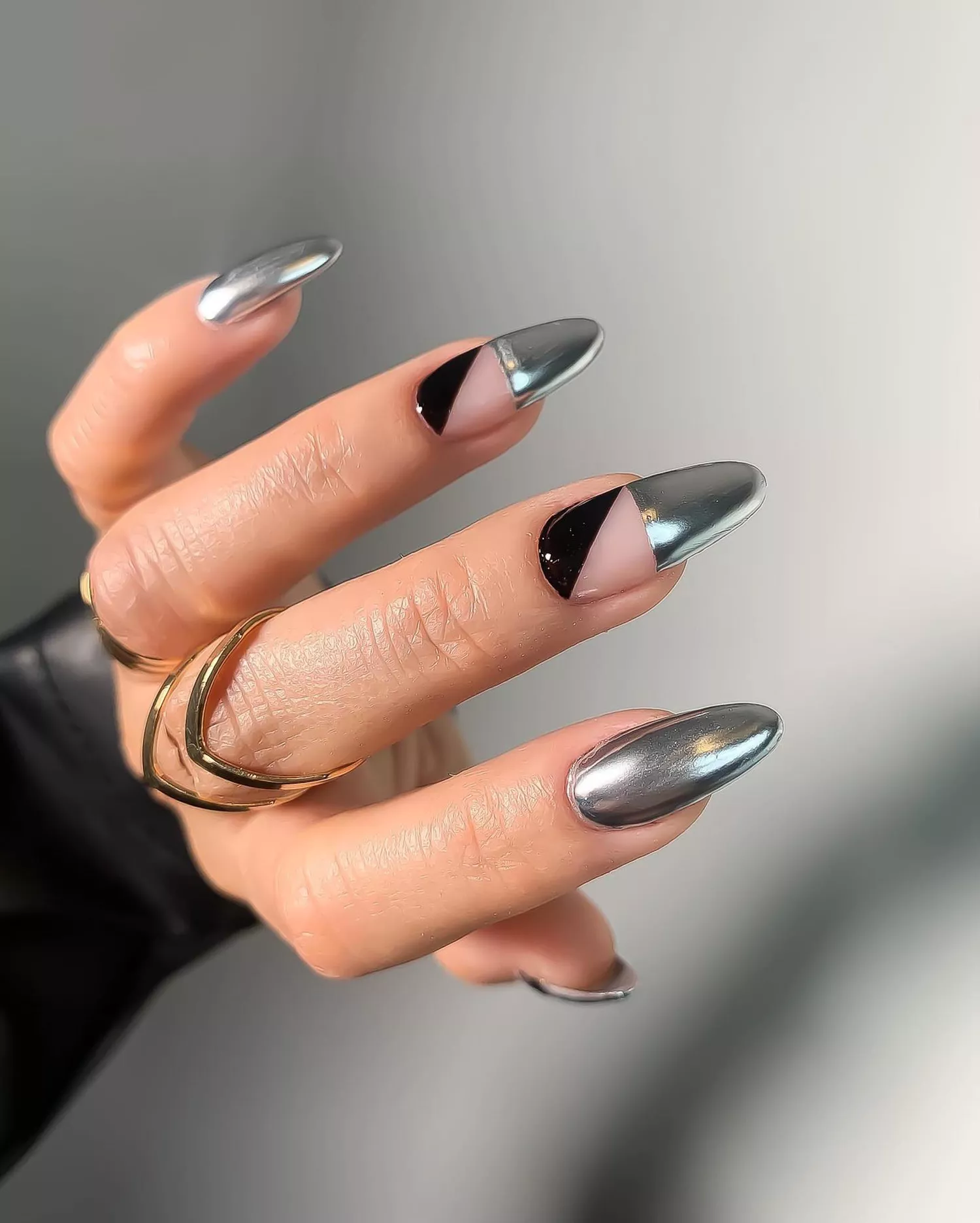 A chrome manicure with negative space/black detail accent nails