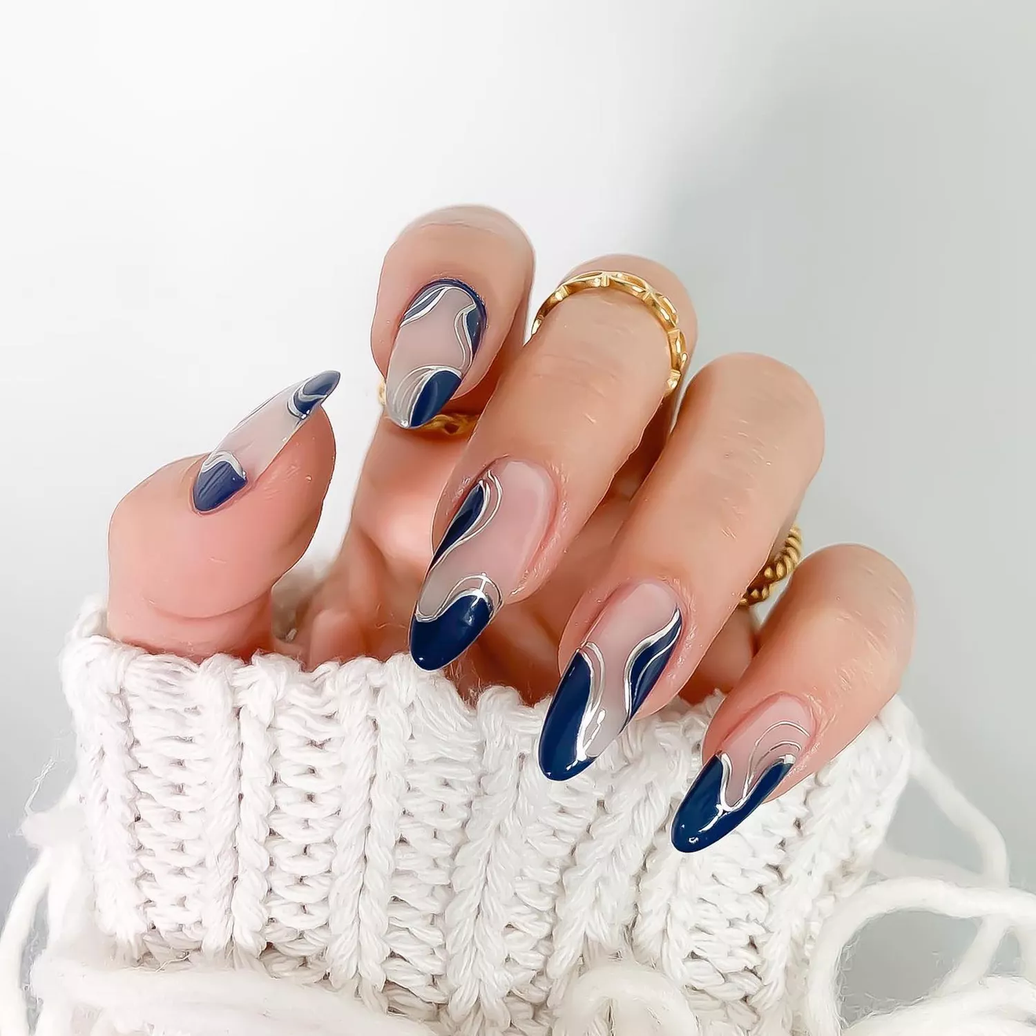 A manicure with navy blue and silver chrome accents